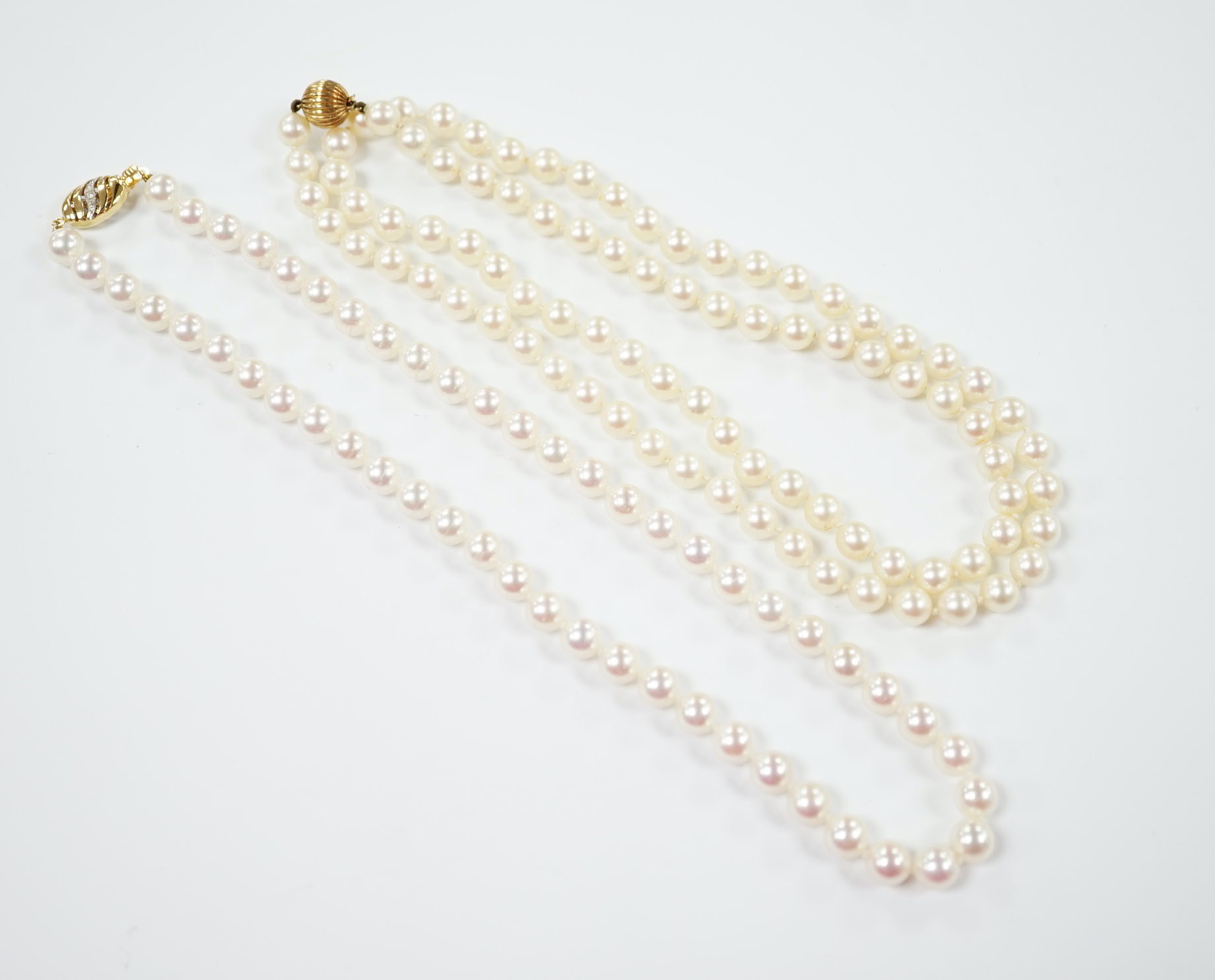 Two single strand cultured pearl necklaces, choker with 750 and diamond chip set clasp, 42cm, the other longer with 14k clasp, 72cm.